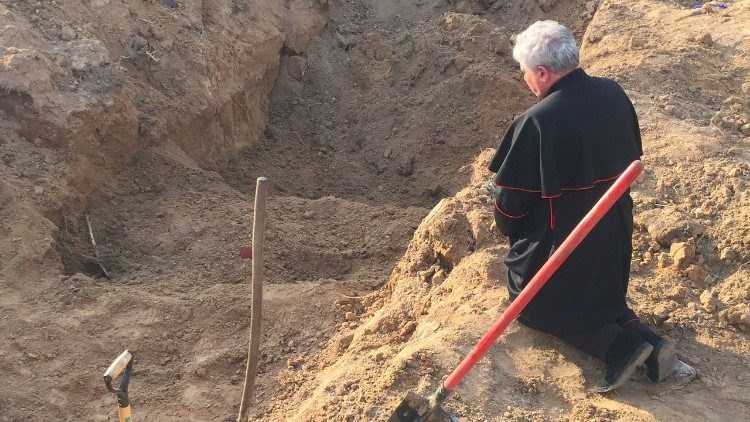 Đức Hồng y Krajewski cầu nguyện tại ngôi mộ tập thể ở Ukraine